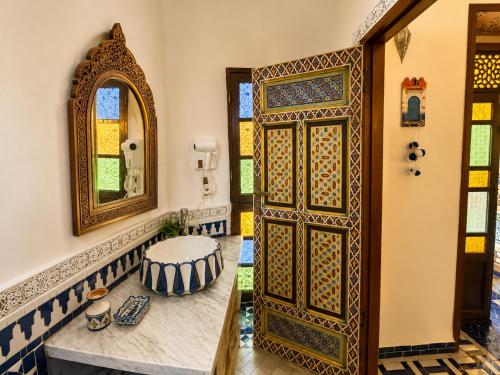 an entrance to a bathroom with a door and a mirror at Riad Dar ElBellar in Fez