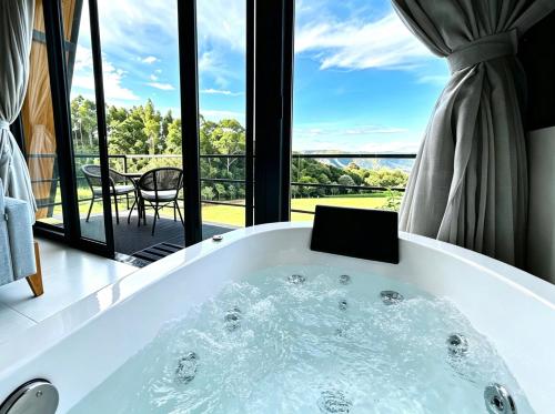 a bath tub in a room with a view at Refugio Pertinho do Céu in São Pedro