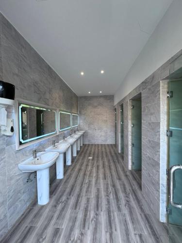 a bathroom with a row of sinks and mirrors at شاليهات Luma الفندقية in Bisha Airport