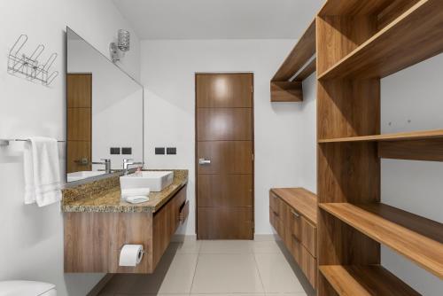 a bathroom with wooden cabinets and a sink at Monyxbnb at Zoho Skies in Puerto Vallarta