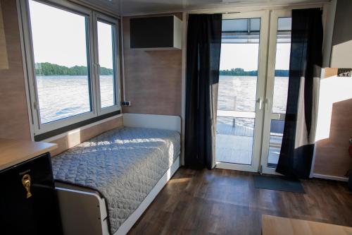 a bedroom with a bed with a view of the water at Houseboat Dąbrowica in Dąbrowica