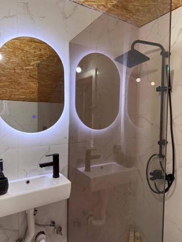 a bathroom with two mirrors and a sink and a shower at House Tickon Ostrog in Trubasinj