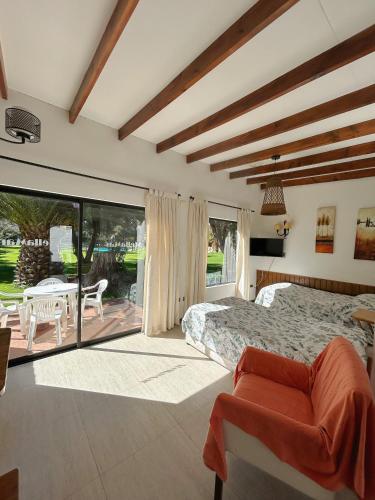 a bedroom with a bed and a patio with a table at Stellamar Apart Hotel in La Serena