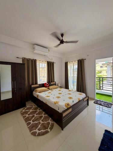 a bedroom with a large bed and a ceiling fan at Eden Stay in Siliguri
