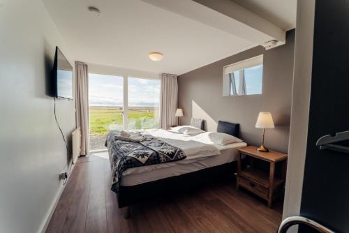 a bedroom with a bed and a large window at Farmhouse in Vík