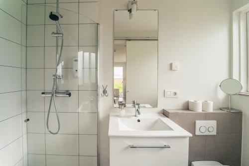 a white bathroom with a sink and a shower at Farmhouse in Vík
