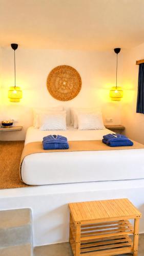a bedroom with a bed with two blue pillows on it at Aegean Serenity - Sea View Retreat in Archangelos