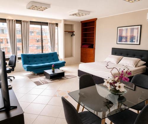 a living room with a bed and a table and chairs at Apartamentos - Torre de Cali in Cali