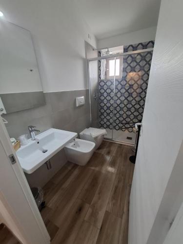a white bathroom with a sink and a toilet at B&B Villa Mariotta in Amantea