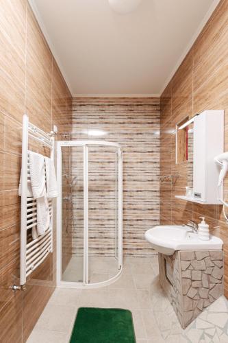 a bathroom with a shower and a sink at Vila Sentandreja in Subotica