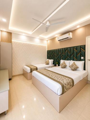 a hotel room with two beds and a television at Hotel Satwah Luxe Stay - 1 Minute From Nizamuddin Railway Station And India Gate in New Delhi