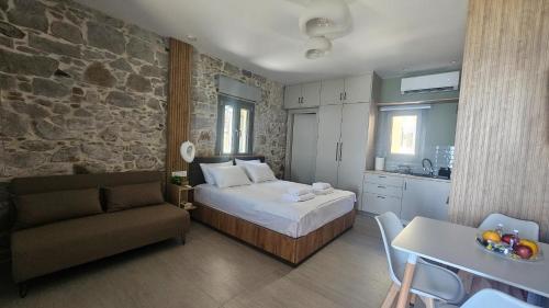 ein Schlafzimmer mit einem Bett, einer Couch und einem Tisch in der Unterkunft BluWave in Kómi