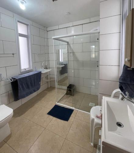 a bathroom with a shower and a toilet and a sink at Pousada Siriemas in Cambará