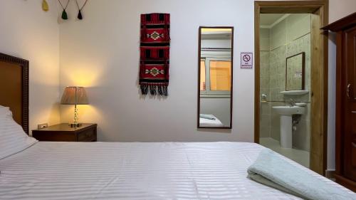 a bedroom with a bed and a sink and a mirror at Atlantis Pyramids Inn in Giza