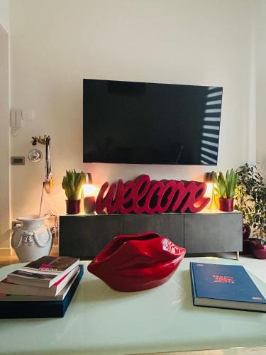 a room with a table with books and a television at La Reggia b&b in Bergamo