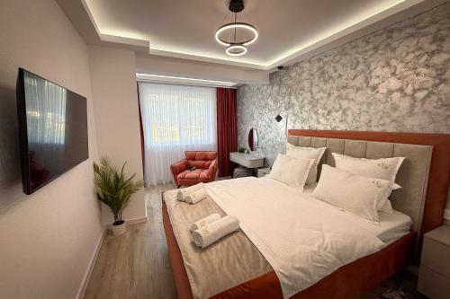 a bedroom with a large bed and a chair at Stay Unique in Râşnov