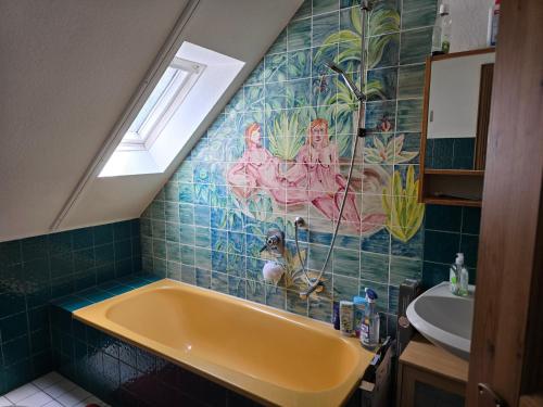 a bathroom with a yellow tub and a sink at idyllisches Mühlengebäude in Hillesheim