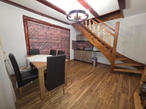 a dining room with a table and a brick wall at Maricom Home in Zărneşti