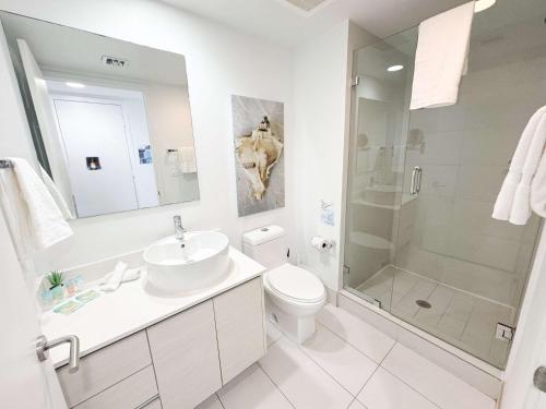 a bathroom with a sink and a toilet and a shower at 30th Fl Beachwalk Studio Bay Balcony in Hallandale Beach