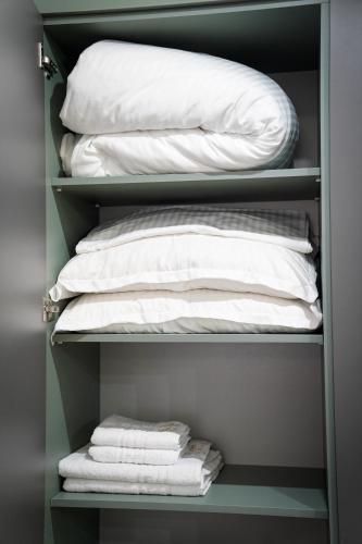 a closet filled with white towels and pillows at Stay Unique in Râşnov