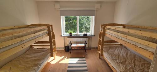 two bunk beds in a room with a window at Frostavallen Hostel in Långstorp