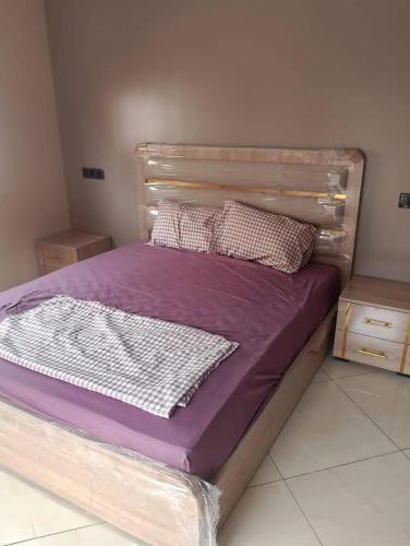 a bed with purple sheets and pillows in a bedroom at The blue door meknes in Meknès