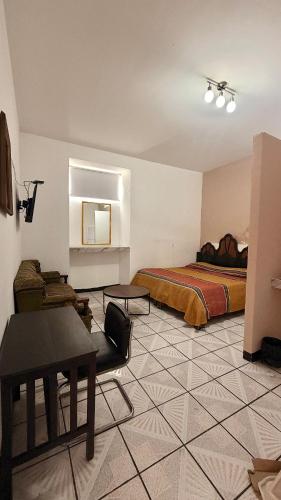 Hotel Dulce Morelia في موريليا: غرفة نوم بها سرير وطاولة