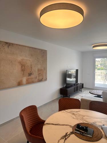 a living room with a table and chairs and a television at Luxury La Cala de Mijas Sunset in Mijas Costa