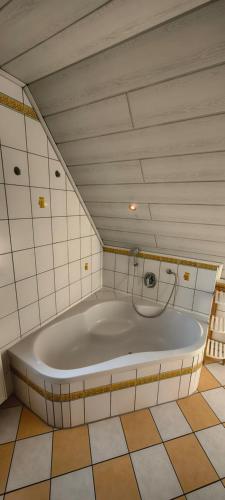 a large bath tub in a room with a tile floor at FeWo Altstadt Herrieden in Herrieden