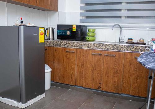 a kitchen with a stainless steel refrigerator and wooden cabinets at Gods Grace homes in Duasi
