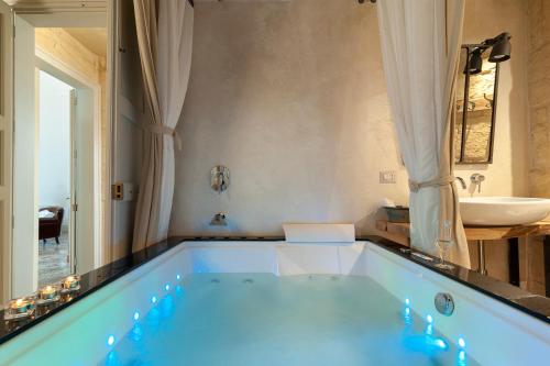 a large blue tub in a bathroom with a sink at Palazzo Mandurino luxury relais in Zollino