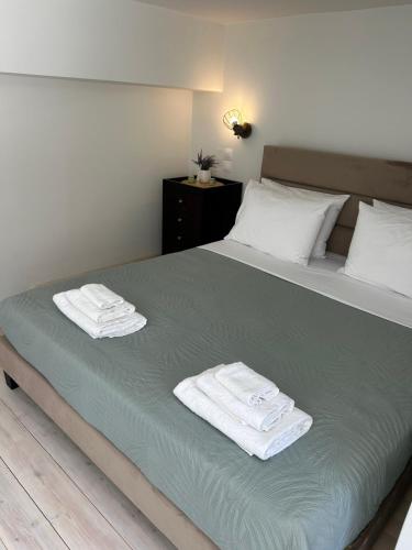 ein Schlafzimmer mit einem Bett, auf dem Handtücher liegen in der Unterkunft Diamond house in Khoríon