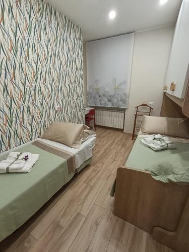 a bedroom with two beds and a wall with a mural at Porta Napoli Holidays in Sulmona
