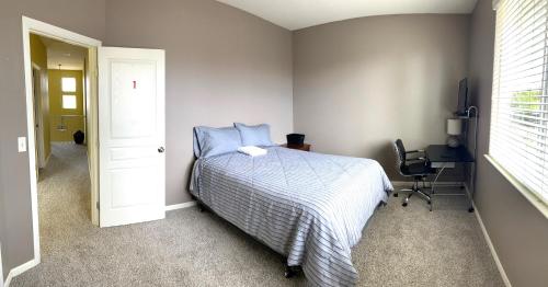a bedroom with a bed and a desk and a chair at la paz room 1 in Fresno