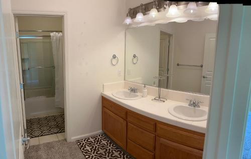 a bathroom with two sinks and a large mirror at la paz room 1 in Fresno
