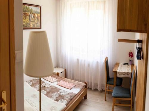 a bedroom with a bed and a desk and a window at Double room, sauna, Masuria in Ruciane-Nida