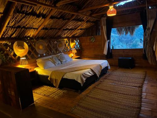 a bedroom with a bed in a room with a window at Hostal Casa Horizonte in Taganga
