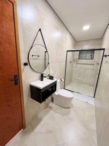 a bathroom with a toilet and a sink and a shower at Hospedaria Santa Inês in Cachoeira Paulista