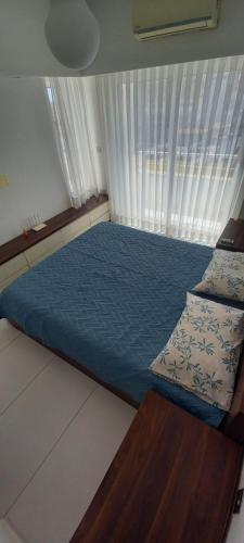 a bedroom with a blue bed and a window at ORAN App in Dherinia