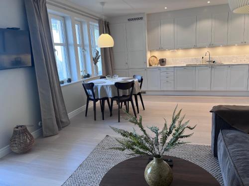 a kitchen and living room with a table and chairs at Fjallbacka, Modern nyproducerad lägenhet med egen parkering och laddning in Fjällbacka