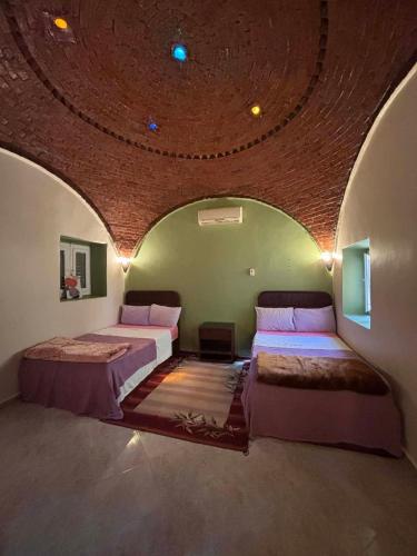 two beds in a room with a circular ceiling at فيلا كوكو بقرية تونس in Tunis