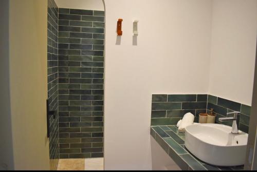 a bathroom with a sink and a green tiled wall at Villa Rosa, 4chambres, piscine , Lecci , 8 personnes in Lecci
