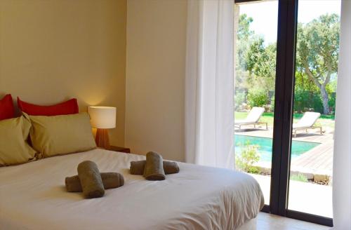 a bedroom with a bed with two stuffed animals on it at Villa Rosa, 4chambres, piscine , Lecci , 8 personnes in Lecci