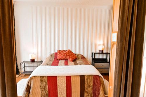 a bedroom with a bed and two night stands at Maison Conteneur d'Expedition in Amos