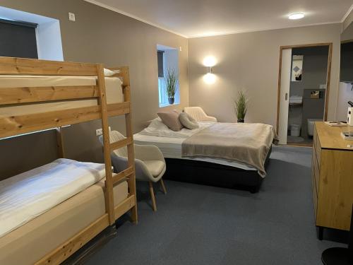 a bedroom with two bunk beds and a desk at Bjarg at Lyngholt in Þórshöfn