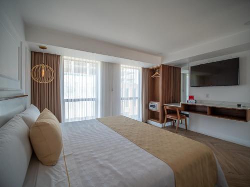 a hotel room with a large bed and a desk at Six Hotel Guadalajara Degollado in Guadalajara