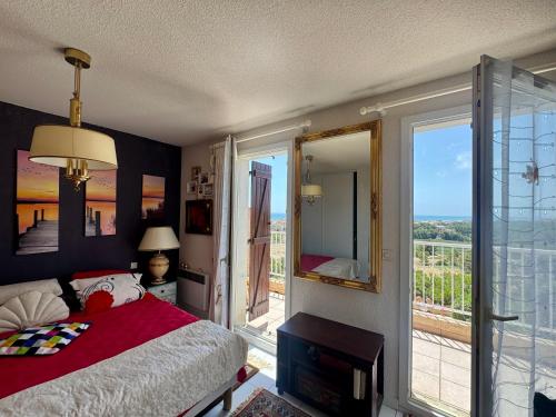a bedroom with a bed and a large window at La Maison de Marianne in Fleury