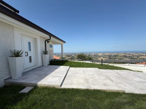 a house with a white door and some grass at B&B Remì in Gemmano
