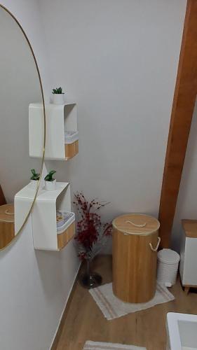 a room with a white wall with a mirror and a stool at A frame ti i ja in Smederevska Palanka
