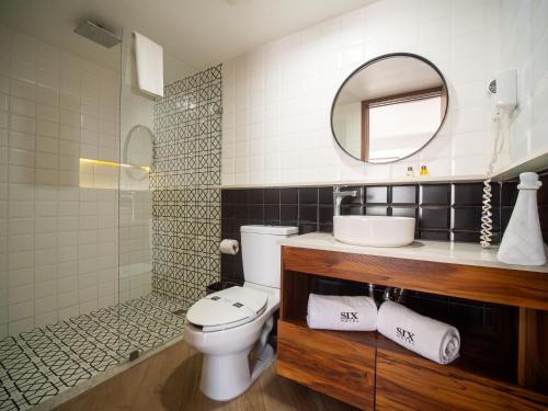 a bathroom with a toilet and a sink and a mirror at Six Hotel Guadalajara Degollado in Guadalajara